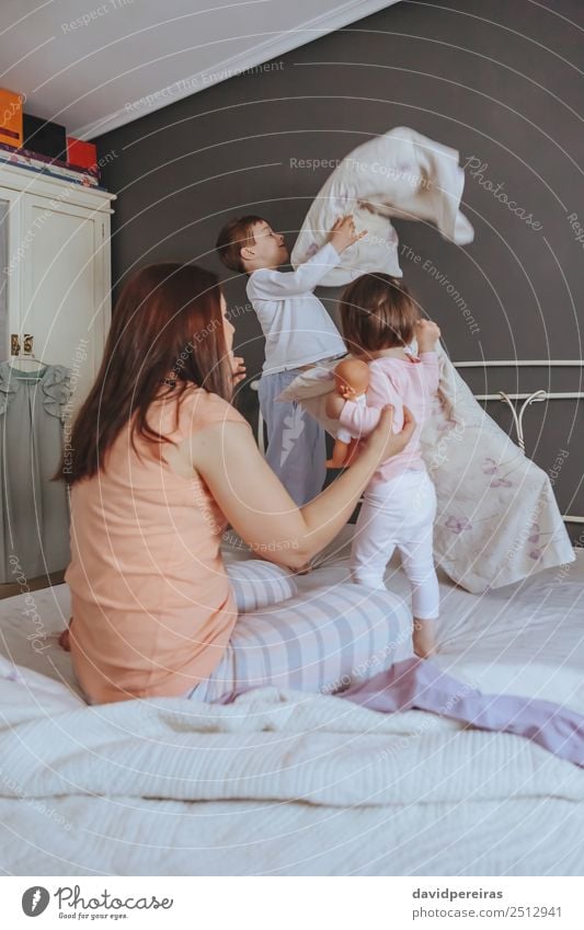 Relaxed mother and sons playing over the bed Lifestyle Joy Happy Beautiful Relaxation Leisure and hobbies Playing Bedroom Child Baby Boy (child) Woman Adults