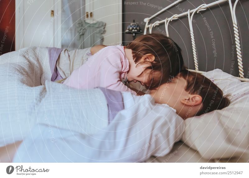 Little girl playing with boy over the bed Lifestyle Joy Happy Beautiful Relaxation Leisure and hobbies Playing Bedroom Child Baby Boy (child) Woman Adults