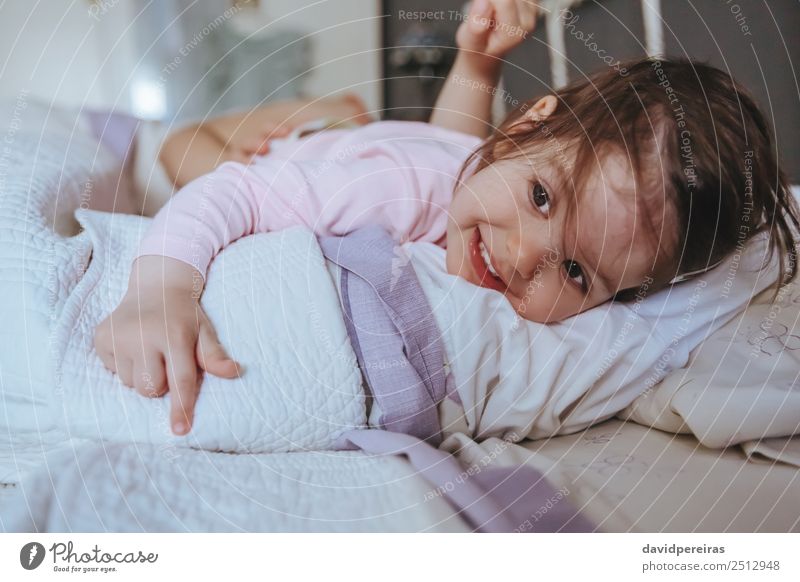 Little girl smiling lying over the bed Lifestyle Joy Happy Relaxation Leisure and hobbies Playing Bedroom Child Human being Baby Woman Adults Parents Mother