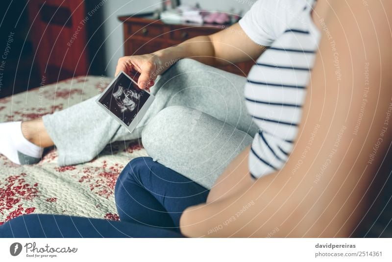 Couple looking at ultrasound of their baby Examinations and Tests Human being Baby Woman Adults Man Parents Mother Father Family & Relations Partner Love Sit