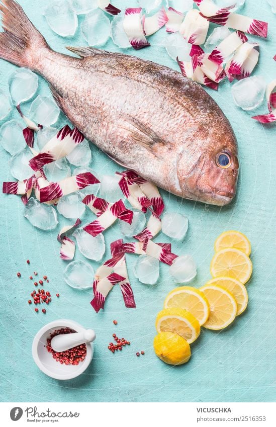 Whole Dorado fish with ice cubes and ingredients Food Fish Nutrition Diet Design Healthy Eating Table Restaurant Pink Style Gourmet Raw Ice cube Lemon