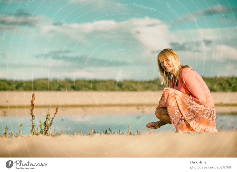 Woman squats at the Baltic Sea beach Lifestyle Style Hair and hairstyles Well-being Contentment Relaxation Vacation & Travel Tourism Trip Summer Summer vacation