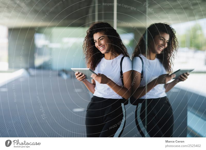 Mixed girl smiling while using her tablet in the city Lifestyle Happy Beautiful Mirror Woman Adults Street Pants Smiling Cute Black african Backpack brown hair