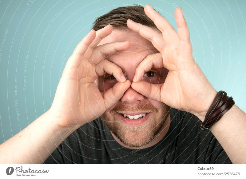 Young man makes with his fingers a gesture around his eyes Style Human being Masculine Youth (Young adults) Head Friendliness Happiness communication eyeglasses