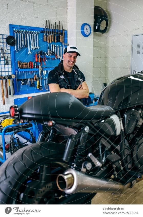 Mechanic posing with a motorcycle Lifestyle Style Happy Work and employment Engines Human being Man Adults Vehicle Motorcycle Smiling Authentic Retro Black