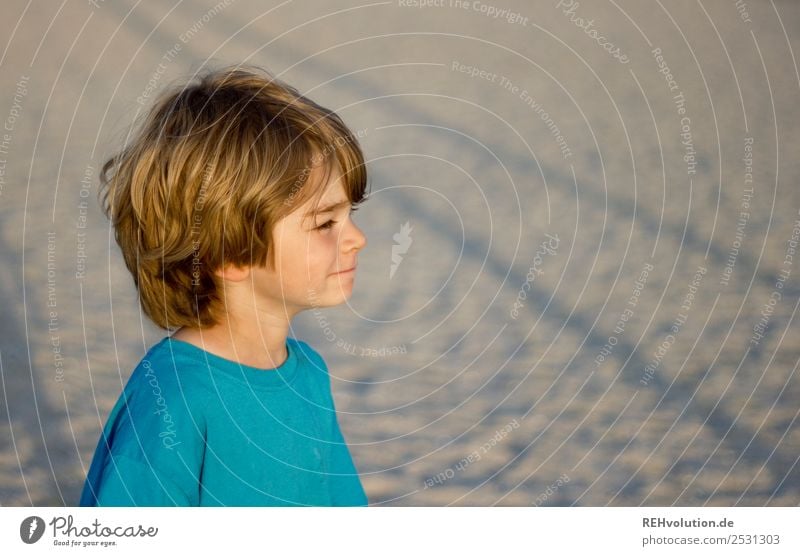 Child standing on the beach Upper body portrait Shallow depth of field Sand naturally Authentic Observe Nature Environment Sun Beach Summer vacation Trip