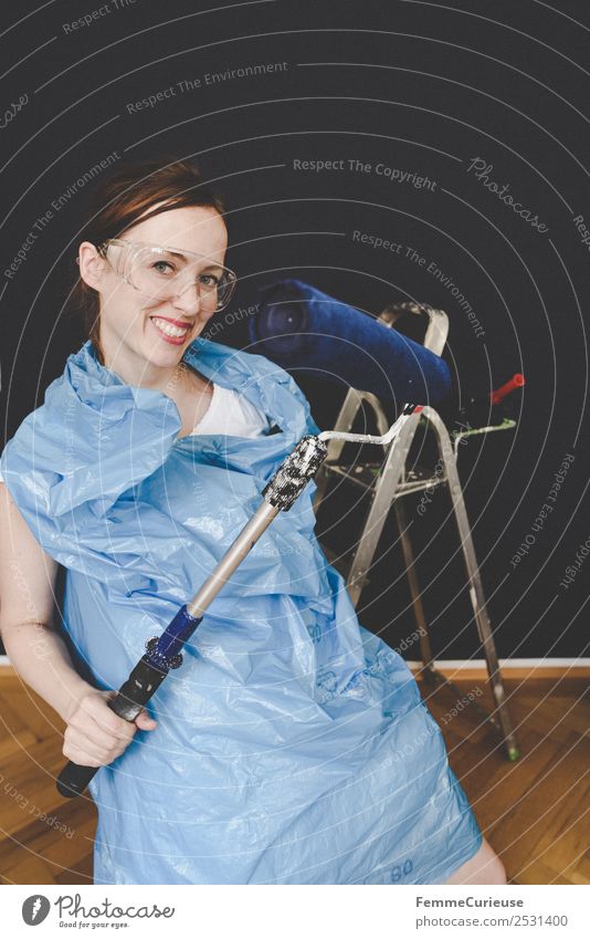 Woman in protective clothes posing with a blue paint roller #DIY Leisure and hobbies Feminine Adults 1 Human being 18 - 30 years Youth (Young adults)