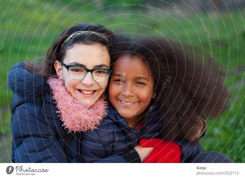 Two happy girls in the park with coats Joy Happy Beautiful Face Winter Child Human being Family & Relations Friendship Infancy Grass Park Coat Scarf Gloves Afro