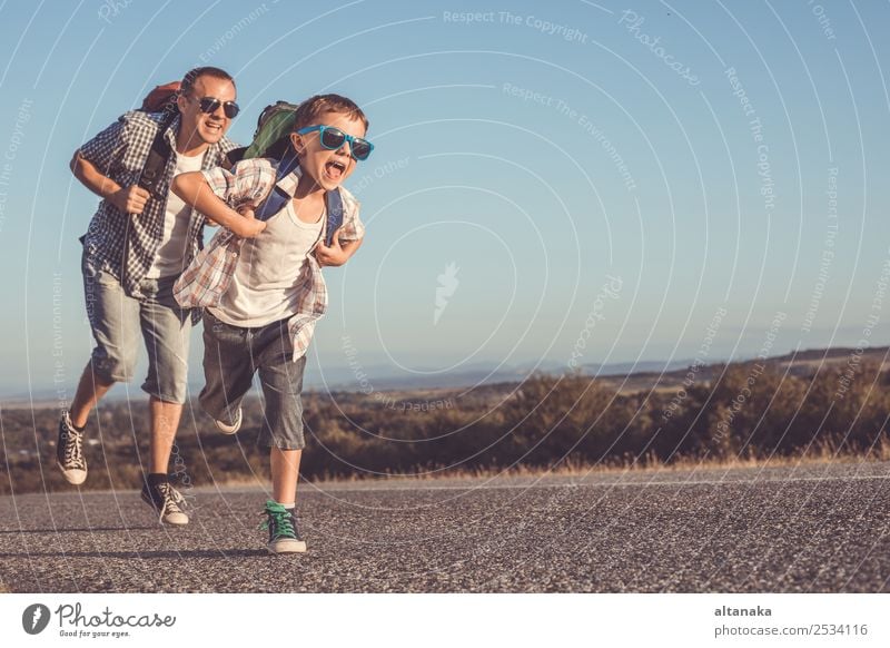 Father and son running on the road at the day time. Concept of tourism. Lifestyle Joy Happy Leisure and hobbies Vacation & Travel Tourism Trip Adventure Freedom