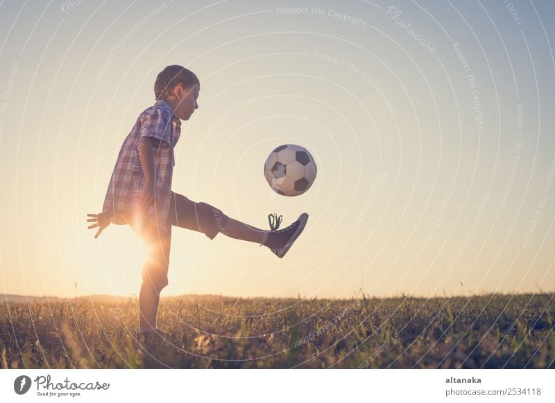 Young little boy playing in the field with soccer ball. Concept of sport. Lifestyle Joy Happy Relaxation Leisure and hobbies Playing Summer Sports Soccer Child