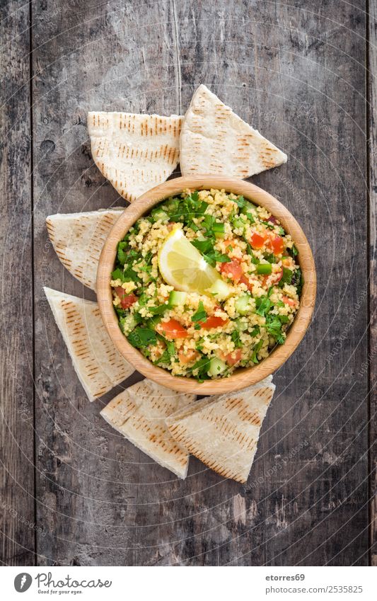 Tabbouleh salad on wooden table Table Salad couscous Vegetable Tomato Cucumber Parsley Mint Vegan diet Vegetarian diet Healthy Eating Nutrition Diet Bowl Lemon