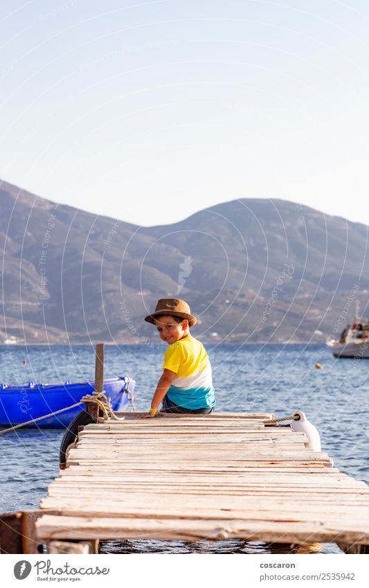 Little boy on a dock sitting on his back looking to the ocean Lifestyle Joy Happy Leisure and hobbies Vacation & Travel Summer Beach Ocean Child Human being