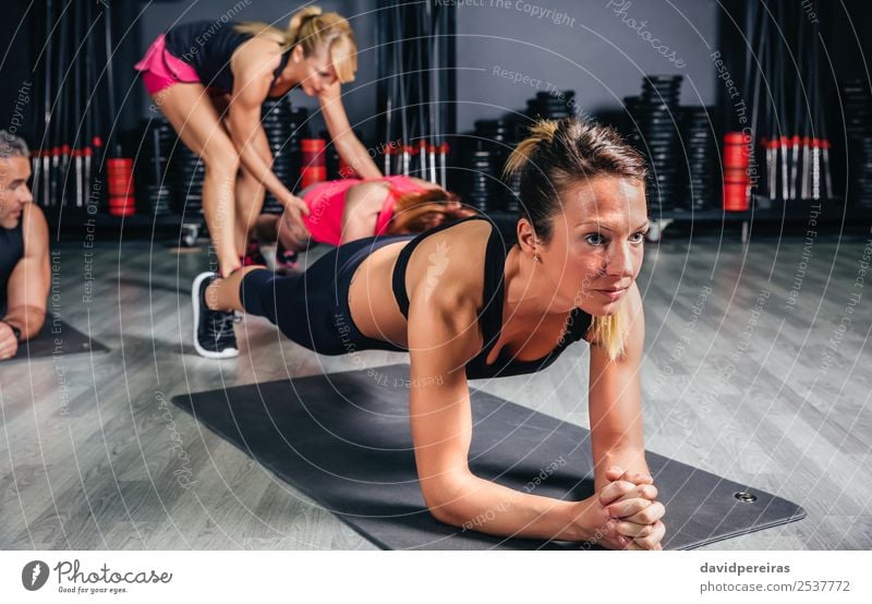 Woman doing push ups with trainer in background Happy Body Sports School Adults Man Arm Group Fitness Authentic Muscular Strong pushup Core Practice Gymnasium