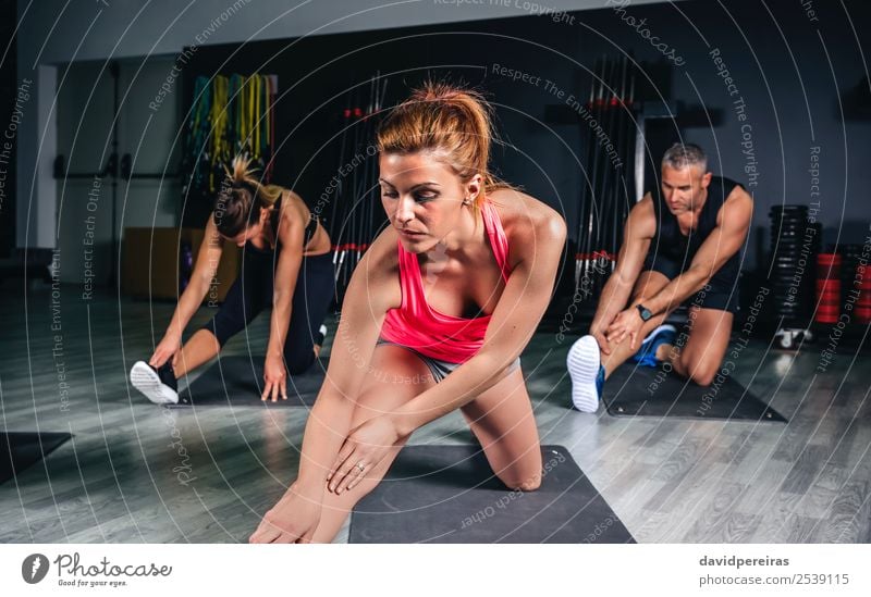 People stretching legs in a fitness class Lifestyle Happy Beautiful Body Leisure and hobbies Club Disco Sports School Woman Adults Man Arm Group Fitness