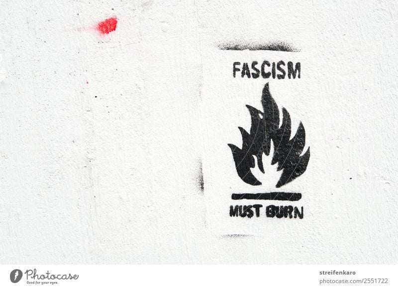 Graffiti against fascism with stylized flame, black writing on white wall House (Residential Structure) Wall (barrier) Wall (building) Stone Concrete Sign