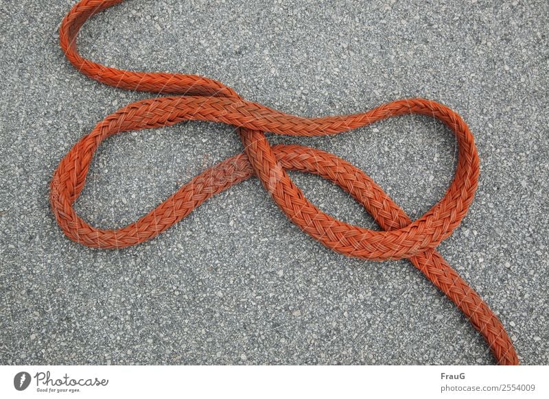 Rope team - infinite Sign Lie Red Infinity Plaited Tattered Asphalt Colour photo Exterior shot Day Downward