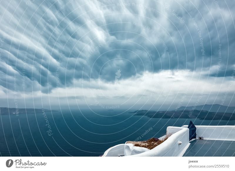 View to the sea from terrace with white wall with unusual clouds in the sky Island Santorini Ocean Sky Clouds Exterior shot Mediterranean sea Cyclades Caldera