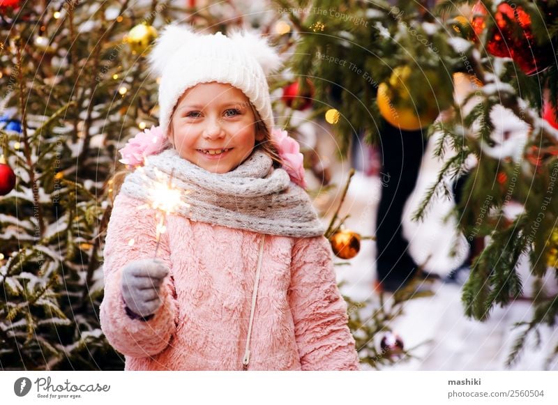 christmas portrait of happy child girl holding burning sparkler Shopping Happy Winter Decoration New Year's Eve Child Infancy Tree Fashion Hat Souvenir Smiling