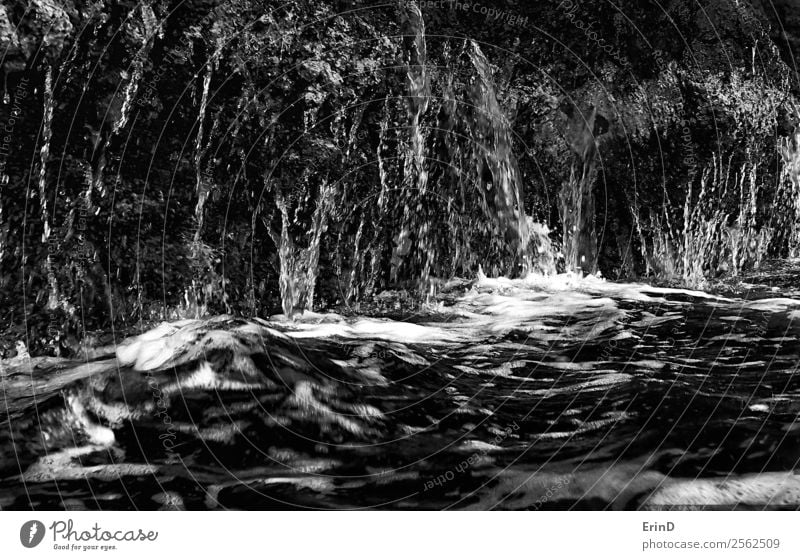 Water Running Off Lava Cliff into Ocean Black and White Close Up Design Nature Rock Wet water drips run off Consistency Dramatic background Flow powerful