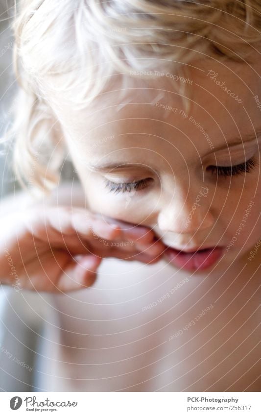 Delicious in the mouth Child Toddler Girl 1 Human being 1 - 3 years Emotions Secrecy Infancy Eyelash Blonde Hand Shallow depth of field Portrait photograph