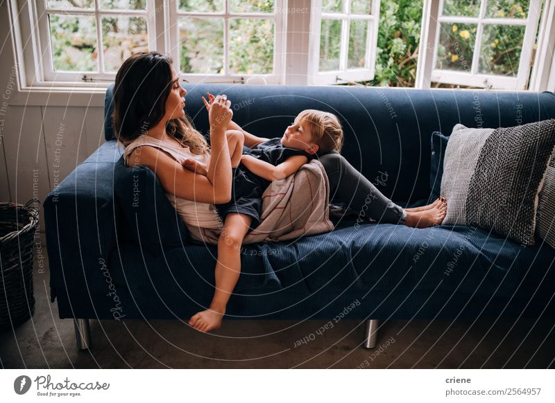 caucasian mother and son relaxing together on couch at home Lifestyle Style Happy Beautiful Relaxation Playing Sofa Parenting Child Boy (child) Woman Adults