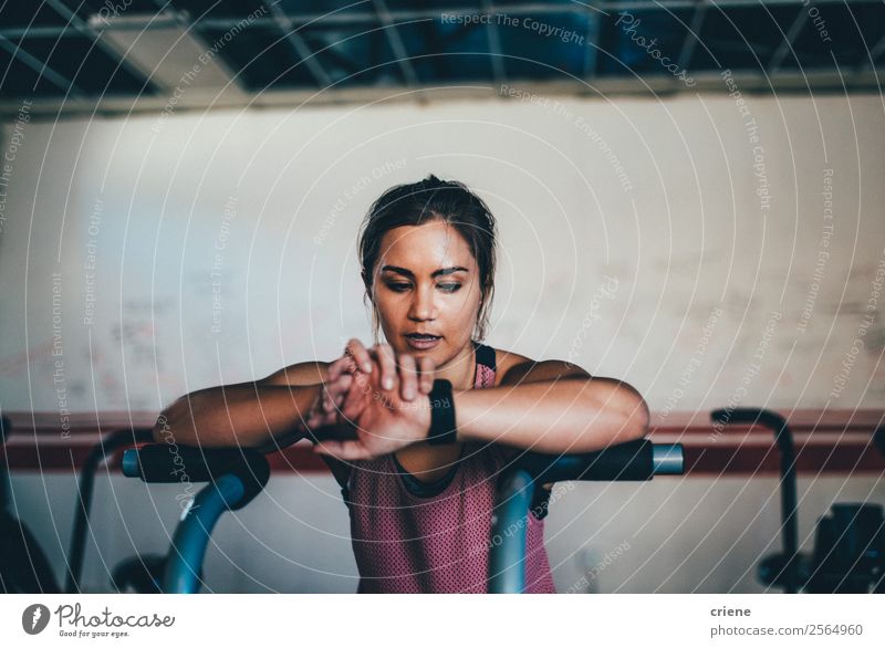 woman checking smartwatch while doing work out in gym Lifestyle Beautiful Body Clock Sports Technology Human being Woman Adults Observe Fitness Smart Gymnasium