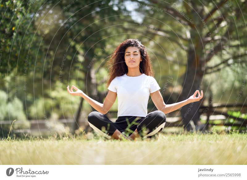 Young woman doing yoga on the grass of urban park. Lifestyle Happy Hair and hairstyles Relaxation Calm Meditation Summer Sports Yoga Human being Feminine