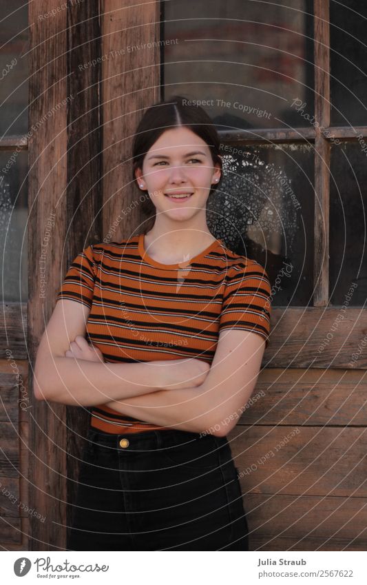 Young woman windows wood Beautiful Window Door T-shirt Brunette Long-haired Braids Smiling Stand Happiness Retro Brown Orange Joie de vivre (Vitality) Fairness