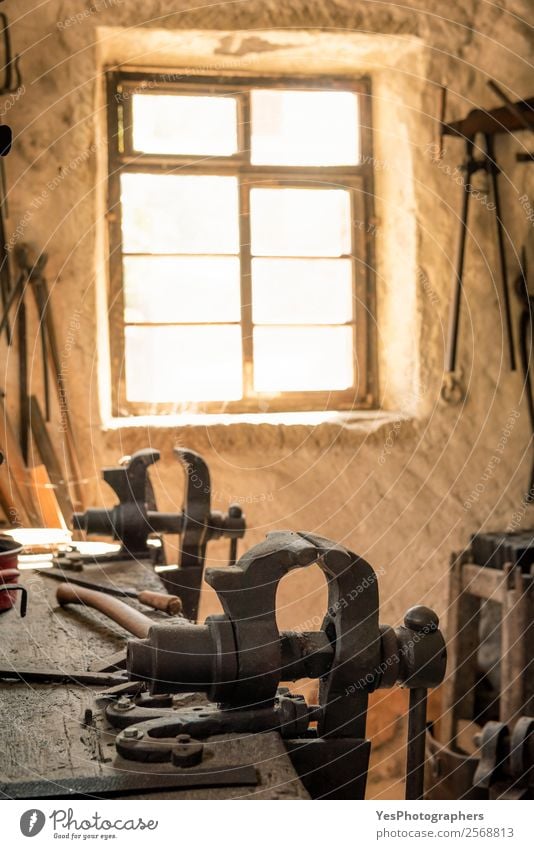 Blacksmith workbench with a vise grip Profession Wall (barrier) Wall (building) Window Old Illuminate Retro Moody Optimism Tradition Ancient Antique Dusty