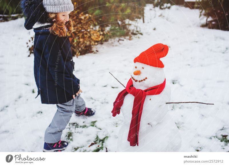 happy kid girl making snow man Joy Leisure and hobbies Playing Vacation & Travel Winter Snow Garden Child Nature Weather Park Clothing Make Snowman walk Action