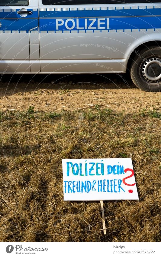 Sign of a demonstrator who questions the task of the police to protect its citizens police violence Field Police Force Disappointment Animosity Police car