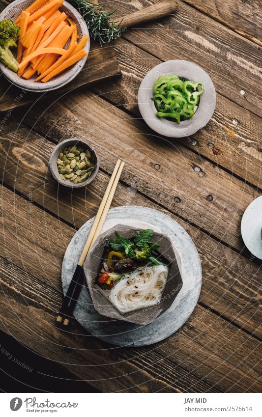 Geometric bowl of Asian Noodle Soup with chopsticks Food Meat Vegetable Stew Lunch Dinner Asian Food Bowl Table Wood Fresh Delicious Green noodle asian Noodles