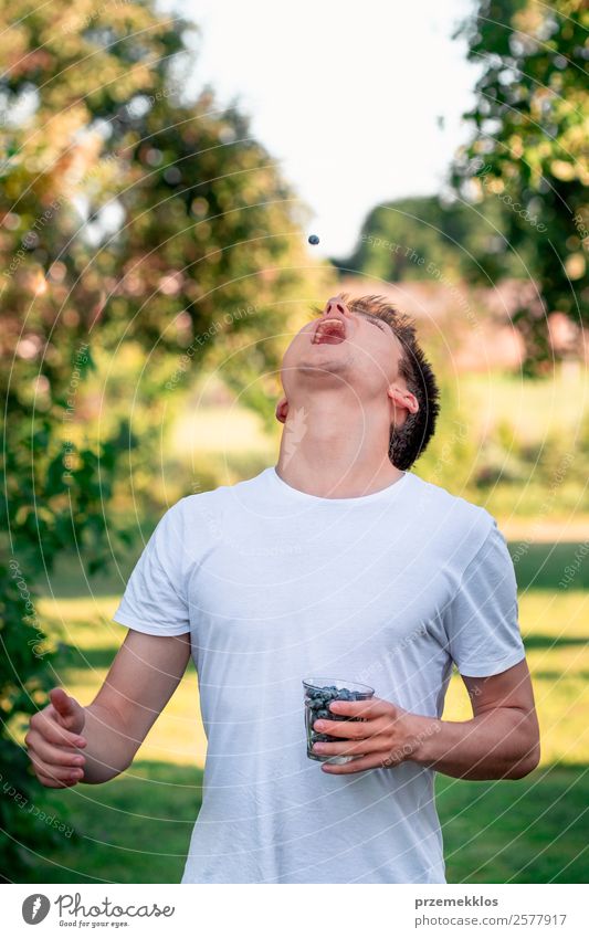 Young boy enjoying eating the fresh blueberries Food Fruit Nutrition Eating Vegetarian diet Glass Lifestyle Joy Summer Garden Human being Young man