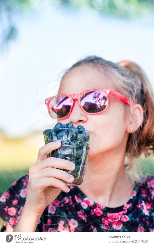 Happy girl enjoying eating the fresh blueberries Food Fruit Nutrition Eating Organic produce Vegetarian diet Diet Glass Lifestyle Summer Garden Human being