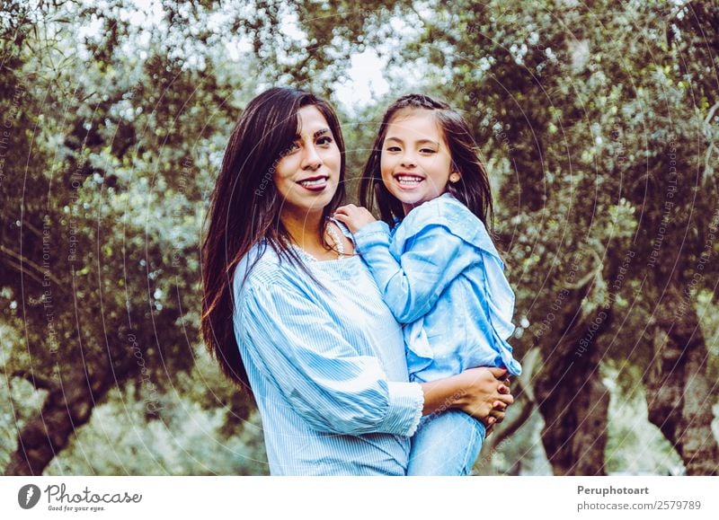 Mother carrying her cute and smiling daughter in the park Human being Child Baby Girl Young woman Youth (Young adults) Woman Adults Parents Family & Relations