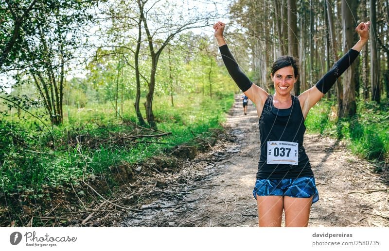 Young woman winning trail race Lifestyle Happy Feasts & Celebrations Sports Success Human being Woman Adults Nature Tree Forest Lanes & trails Sneakers Fitness