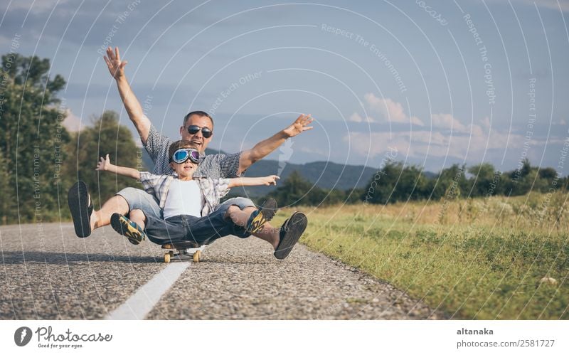 Father and son playing on the road at the day time. People having fun outdoors. Concept of friendly family. Lifestyle Joy Happy Leisure and hobbies Playing