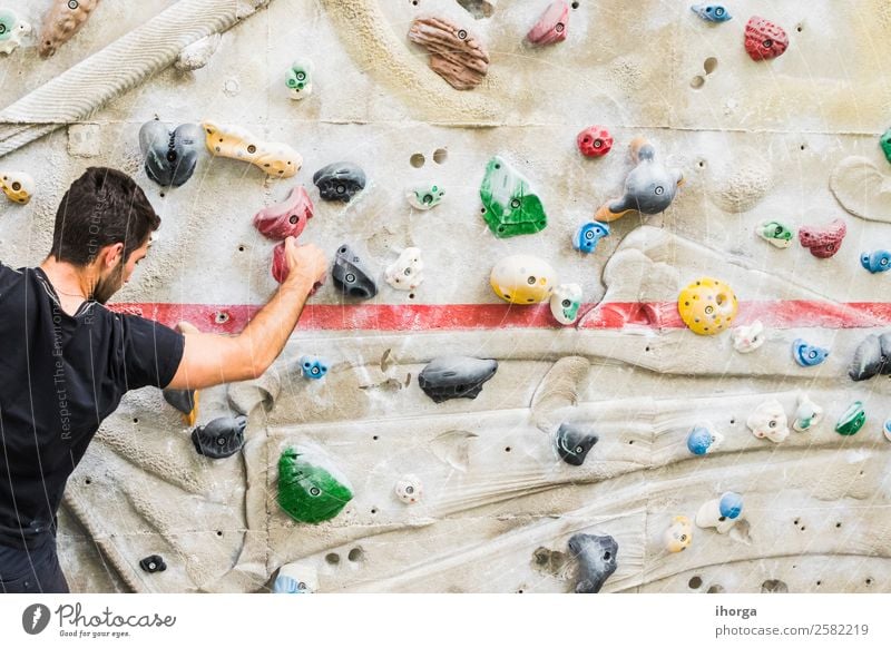 A Man practicing rock climbing on artificial wall indoors Lifestyle Joy Leisure and hobbies Sports Climbing Mountaineering Young man Youth (Young adults) Adults