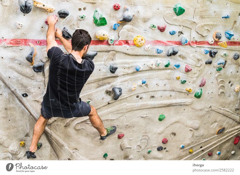 A Man practicing rock climbing on artificial wall indoors Lifestyle Joy Leisure and hobbies Sports Climbing Mountaineering Young man Youth (Young adults) Adults