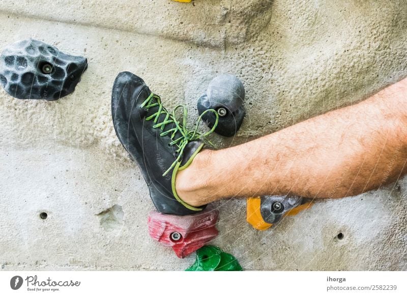 A Man practicing rock climbing on artificial wall indoors. Lifestyle Joy Leisure and hobbies Sports Climbing Mountaineering Masculine Adults Legs Feet