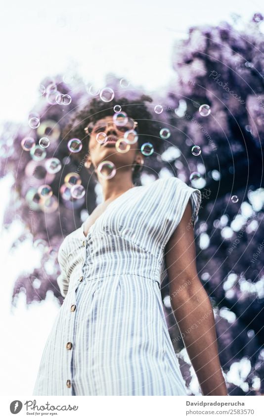 Happy young black woman surrounded by flowers Lifestyle Beautiful Relaxation Summer Garden Woman Adults Nature Tree Flower Blossom Dress Sunglasses Smiling