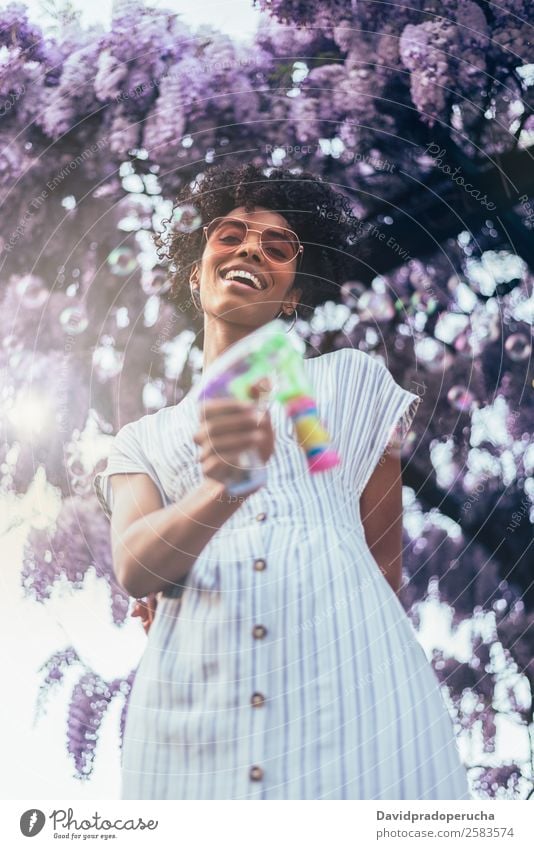 Happy young black woman surrounded by flowers Woman Blossom Spring Lilac Portrait photograph multiethnic Flower Black African Mixed race ethnicity Smiling