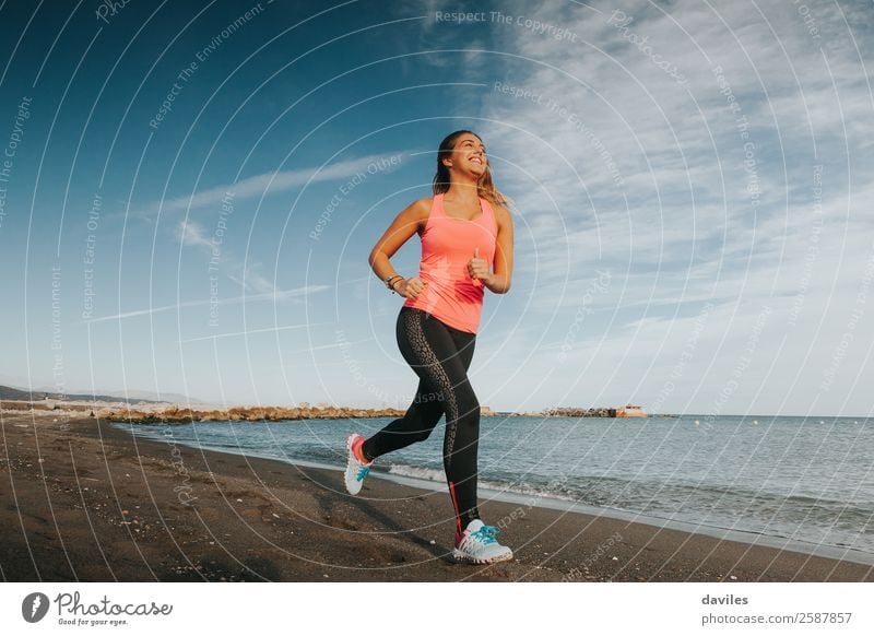 Woman with sports clothes running by the sea shore Lifestyle Athletic Fitness Wellness Beach Ocean Sports Sports Training Jogging Human being Feminine