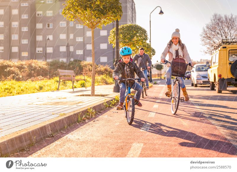 Happy family with a child riding bicycles by the city Lifestyle Relaxation Leisure and hobbies Vacation & Travel Sun Winter Sports Child Boy (child) Woman