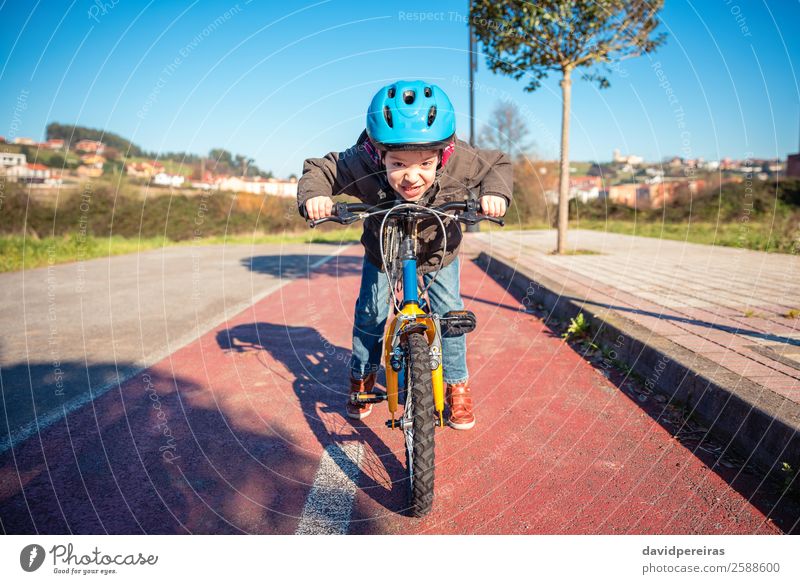 Naughty boy with defiant gesture over bike on a cycleway Lifestyle Joy Happy Face Leisure and hobbies Playing Sun Winter Sports Cycling Child Human being