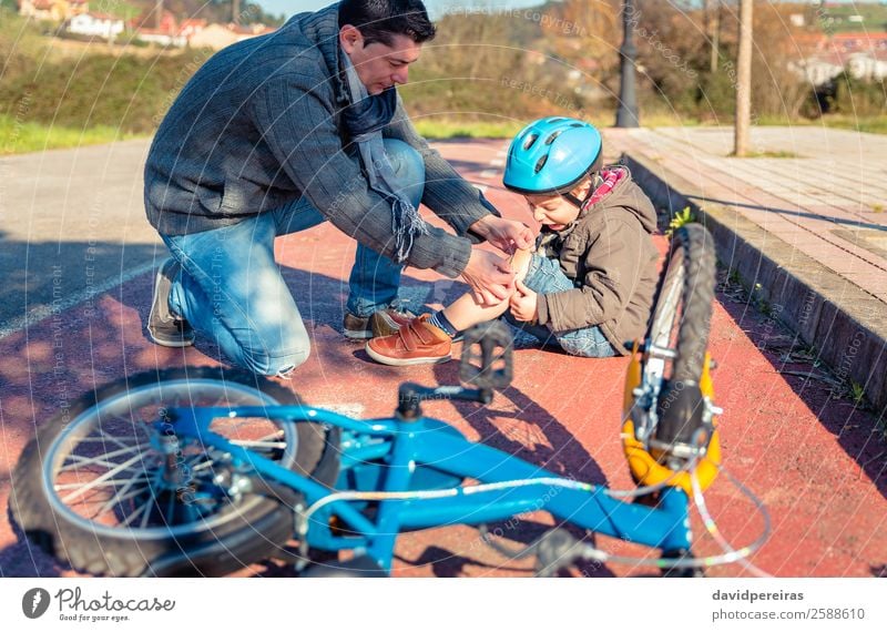 Father putting a plaster band over knee injury to son Medication Sports Cycling Child Boy (child) Man Adults Band Street Lanes & trails Scream Sadness Cry