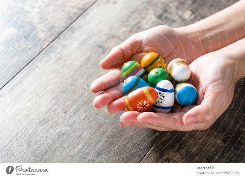 Hands showing Easter eggs, on wooden table. Vacation & Travel Decoration Feasts & Celebrations Spring Flower Tulip Wood Colour Tradition Indicate Egg Festive