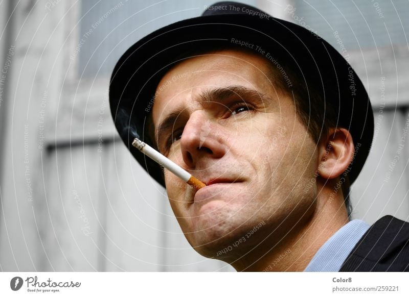 Gangster or policeman on the lookout with filter cigarette Human being Man Adults Head Face 1 30 - 45 years Cinema Film industry Video Garage door Hat