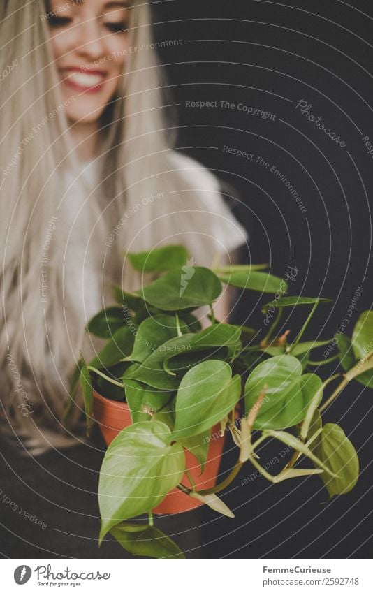 Young smiling woman with long hair showing a plant Lifestyle Elegant Style Design Feminine Young woman Youth (Young adults) Woman Adults 1 Human being