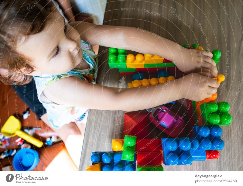 Little girl playing with toy blocks Joy Happy Leisure and hobbies Playing Child Infancy Hand Building Toys Plastic Sit Small Colour Creativity kid construction